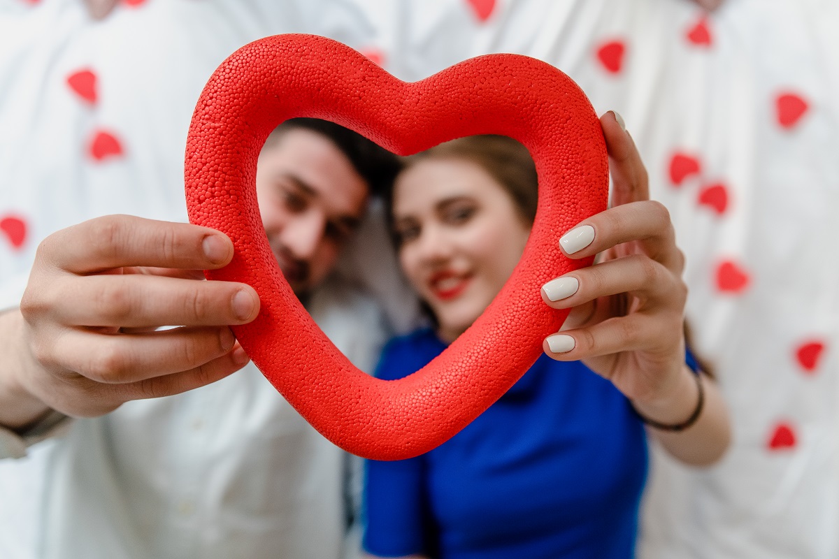 man and woman in love in bed with heart shapes