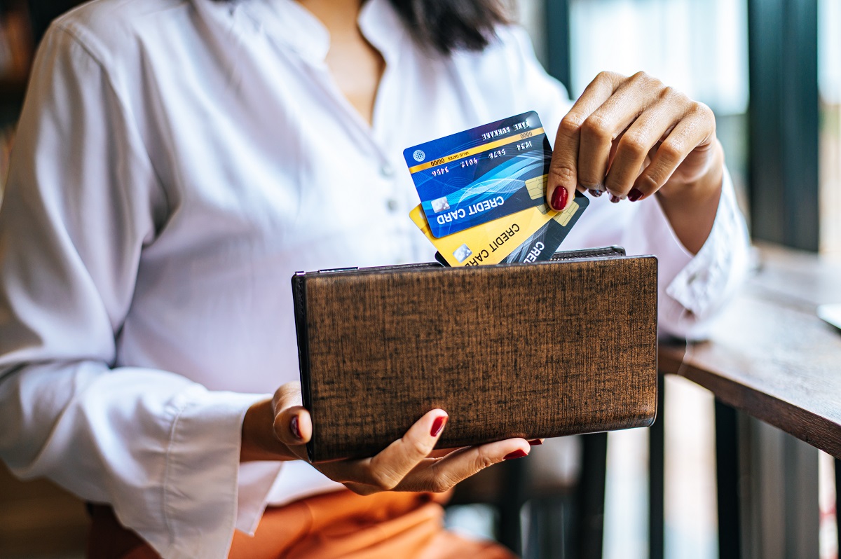 Accepting credit cards from a brown purse to pay for goods on co