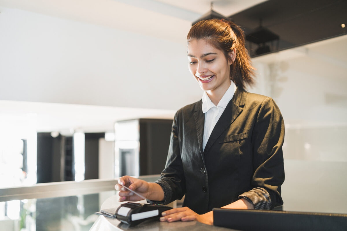 Hotel receptionist swiping a credit card